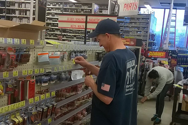 A DisplayMax team member arranging product on a newly installed Lozier retail fixture