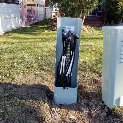DisplayMax electrical utility pedestal installation showing exposed underground conduit cables.