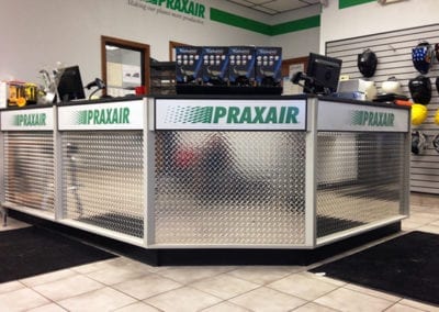 DisplayMax team–installed Praxair front sales counter showcasing custom retail fixture design.